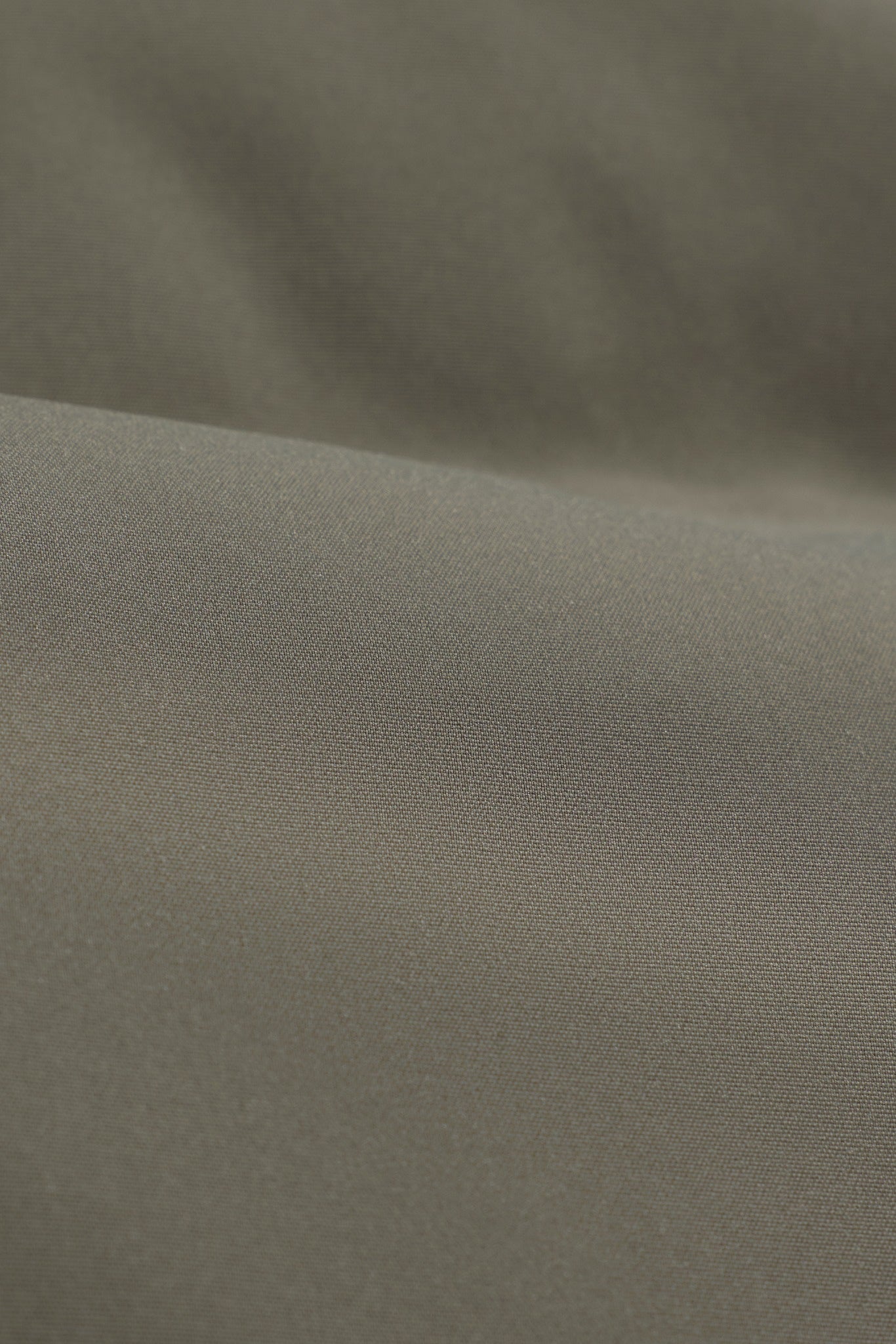 Close-up of the khaki woven fabric on the CASPARA Aurora puffer vest.